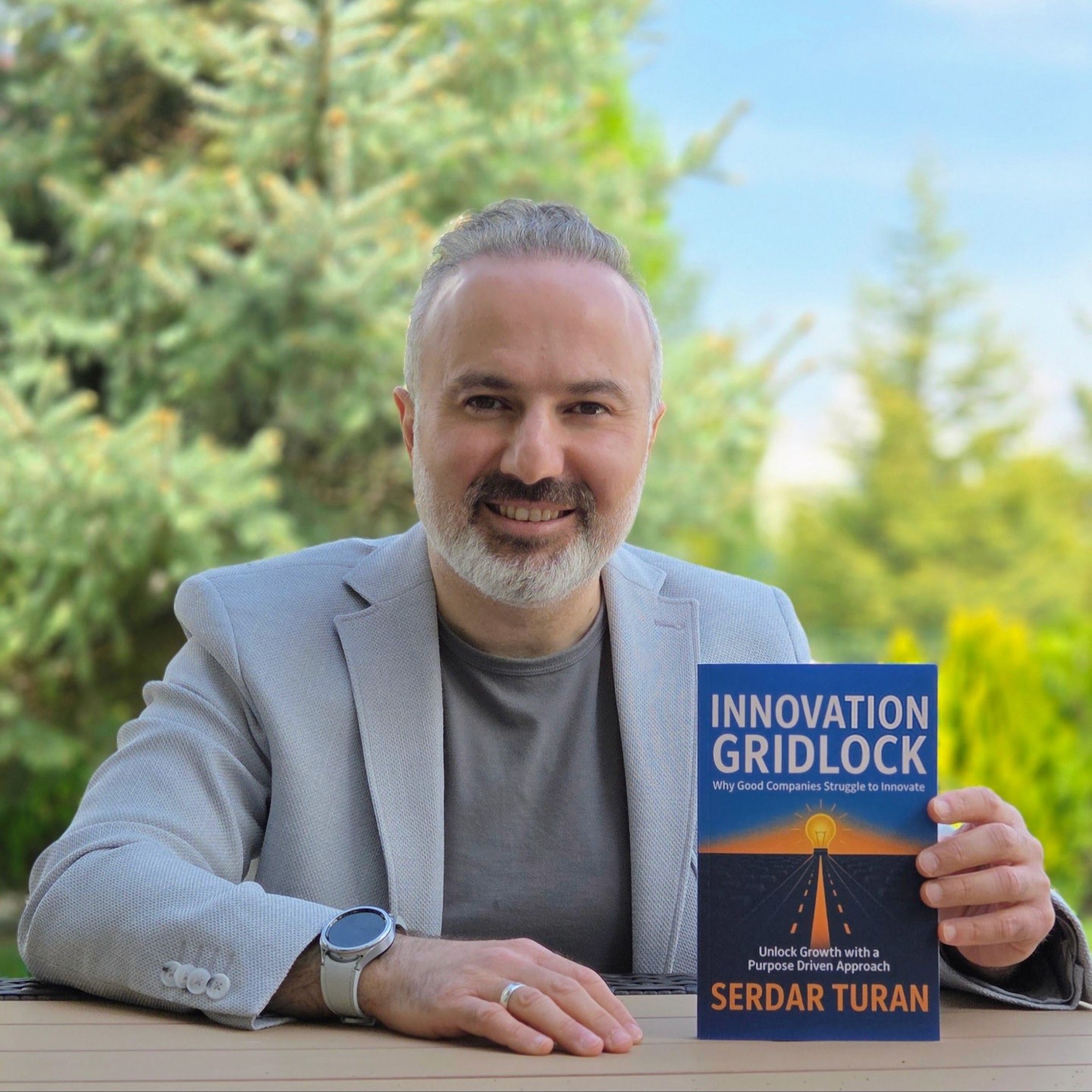 Serdar Turan holding his book, Innovation Gridlock
